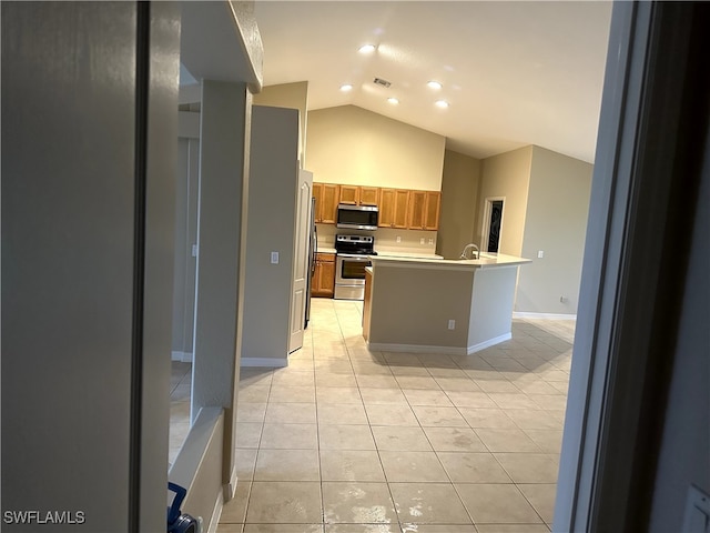 kitchen with light tile patterned floors, high vaulted ceiling, an island with sink, and appliances with stainless steel finishes