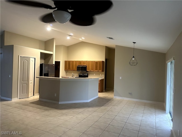 kitchen with lofted ceiling, hanging light fixtures, light tile patterned floors, appliances with stainless steel finishes, and a kitchen island with sink