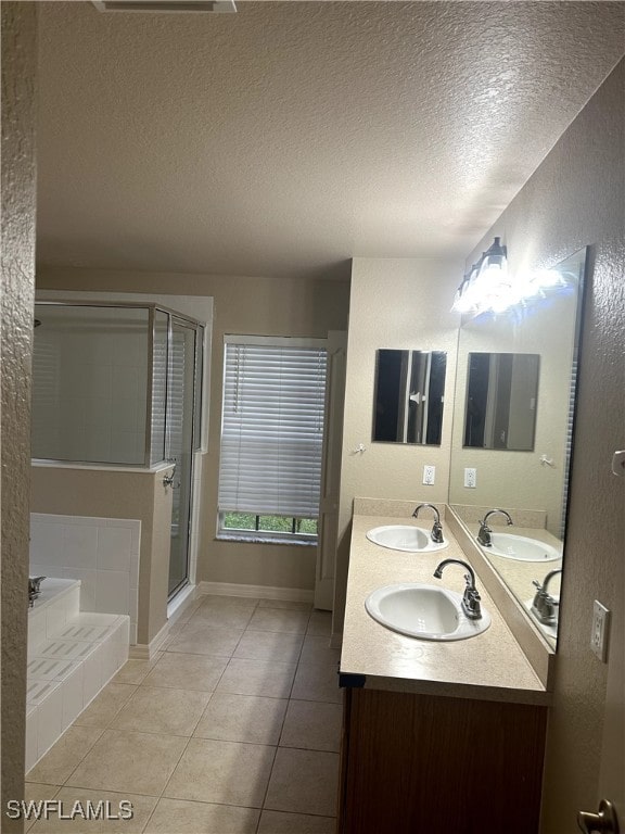 bathroom with plus walk in shower, tile patterned floors, a textured ceiling, and vanity