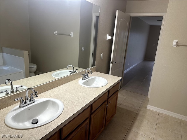 bathroom featuring vanity, tile patterned floors, a bathing tub, and toilet