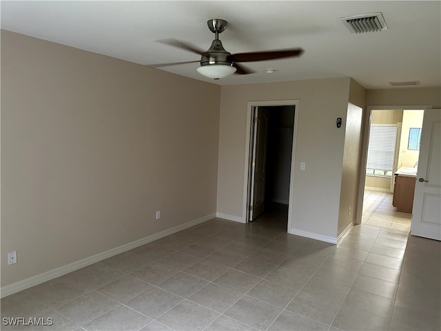 spare room with ceiling fan and light tile patterned floors