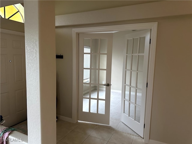 doorway to outside with light tile patterned flooring and french doors