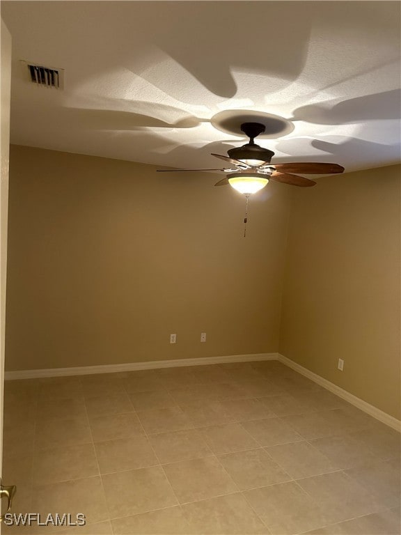 tiled empty room featuring ceiling fan