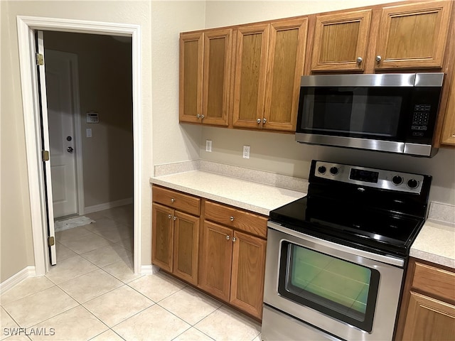 kitchen with light tile patterned flooring and appliances with stainless steel finishes