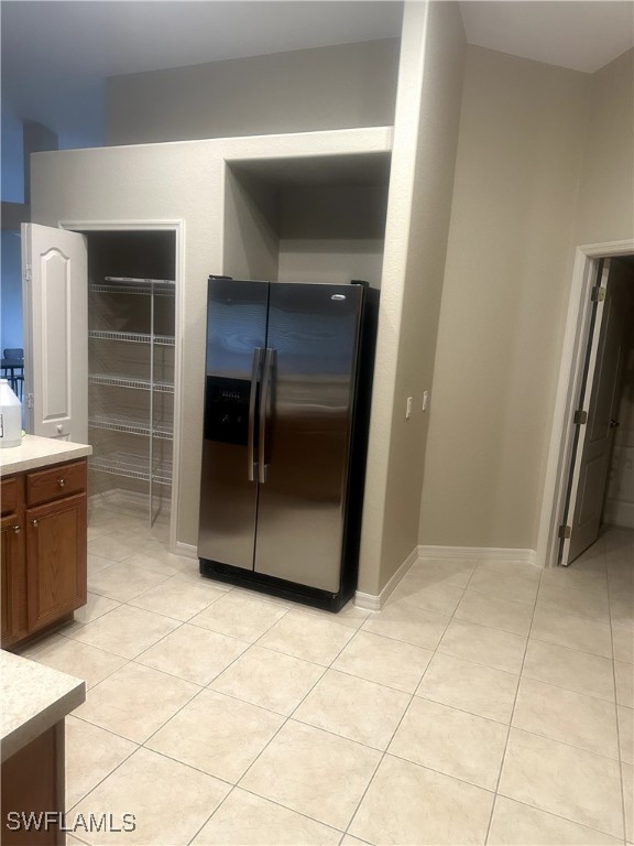 kitchen featuring light tile patterned floors and stainless steel refrigerator with ice dispenser