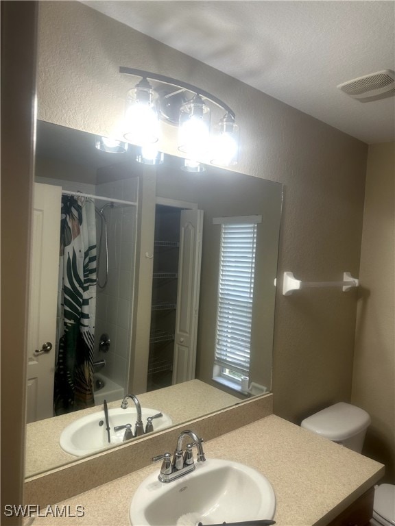 full bathroom featuring vanity, shower / bath combo, and toilet