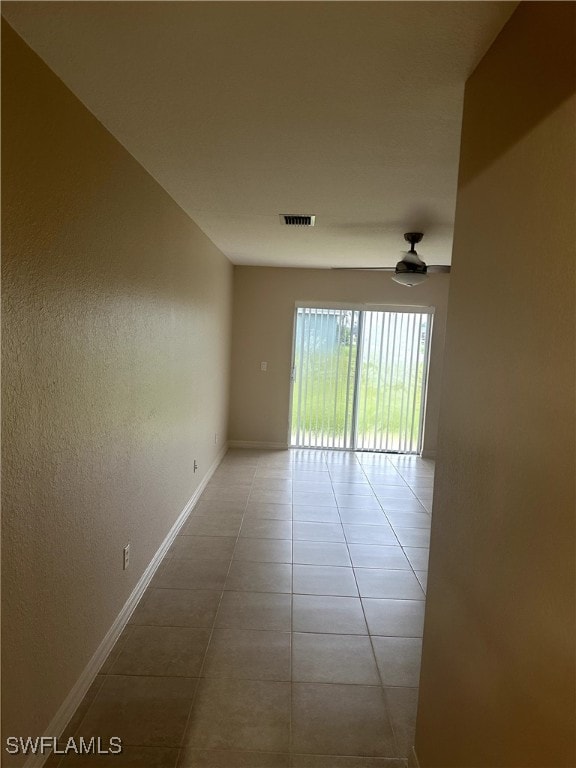 tiled empty room with ceiling fan