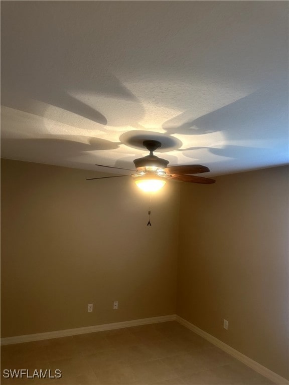 unfurnished room featuring ceiling fan and baseboards