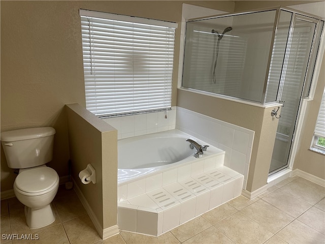 bathroom featuring tile patterned floors, a shower stall, toilet, and a bath