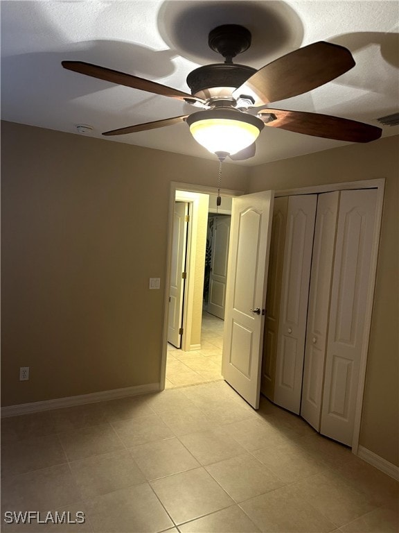 unfurnished bedroom featuring a ceiling fan, a closet, visible vents, and baseboards