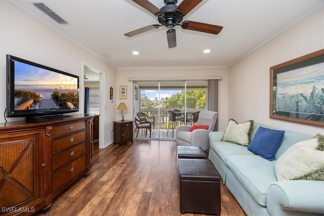 living room with dark wood-type flooring, ceiling fan, and ornamental molding