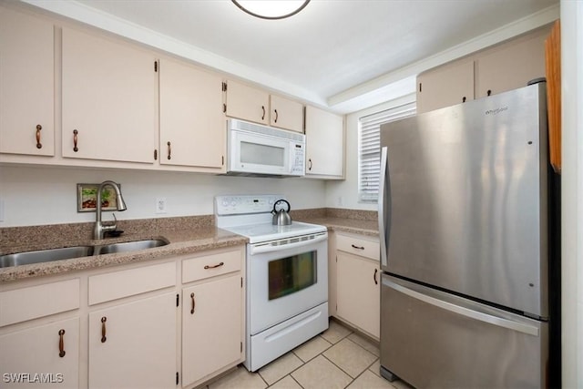 kitchen featuring light tile patterned flooring, white appliances, and sink