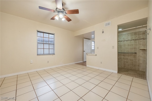 tiled empty room with a healthy amount of sunlight and ceiling fan