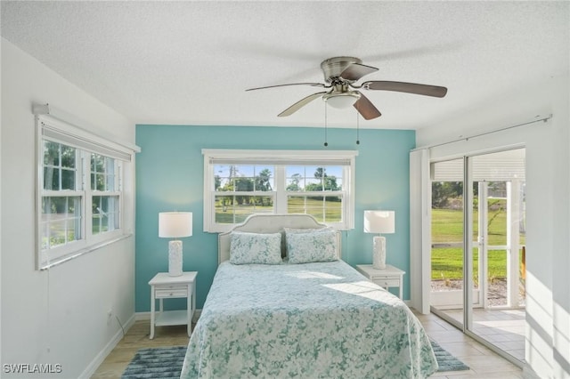 bedroom featuring ceiling fan, access to exterior, and a textured ceiling