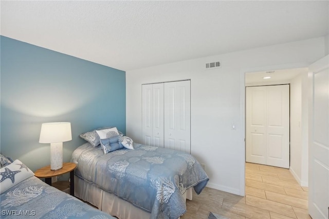15400 River Vista Dr Unit 301, North Fort Myers, FL 33917 - bedroom with wood tiled floor, a closet, visible vents, and baseboards