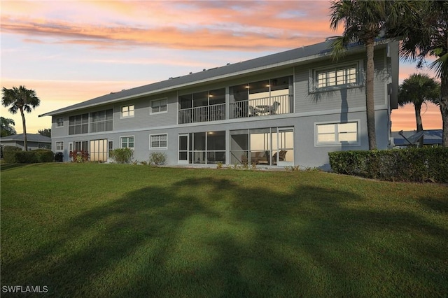 15400 River Vista Dr Unit 301, North Fort Myers, FL 33917 - back of house at dusk featuring a yard and stucco siding