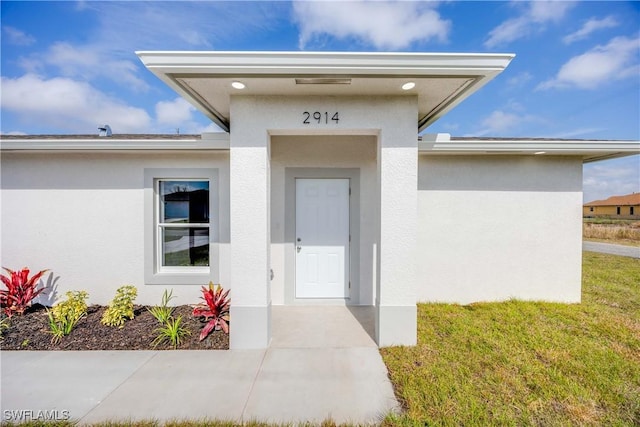 doorway to property featuring a yard