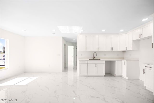 kitchen featuring sink and white cabinets