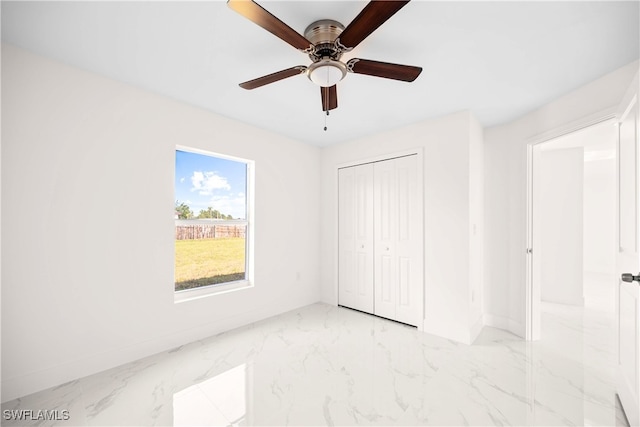 unfurnished bedroom with ceiling fan and a closet