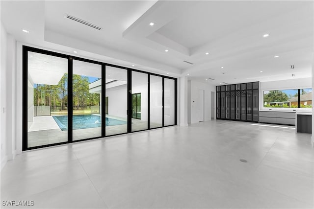 unfurnished room featuring expansive windows and a tray ceiling