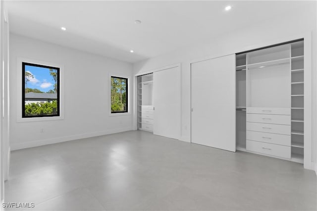 unfurnished bedroom featuring multiple closets and multiple windows