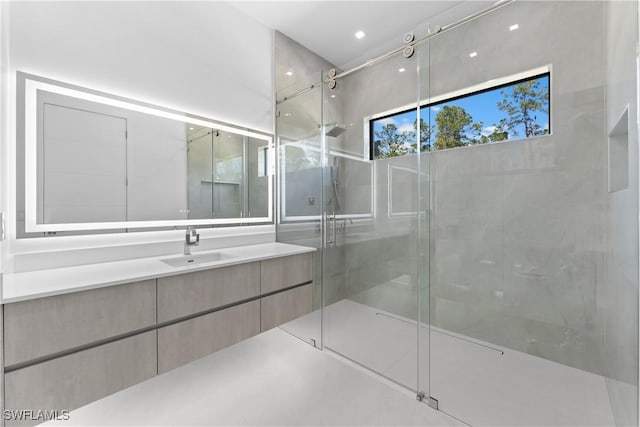bathroom featuring vanity and a shower with door