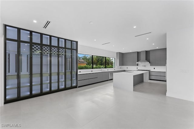 kitchen featuring sink, dishwasher, a center island, and wall chimney exhaust hood