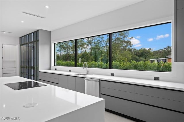 kitchen with black electric stovetop, gray cabinets, sink, and dishwasher