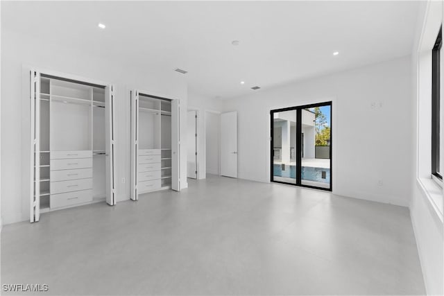 unfurnished bedroom featuring multiple closets and access to exterior
