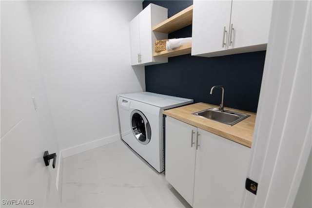 laundry area featuring cabinets, sink, and washer / clothes dryer