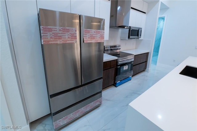 kitchen featuring white cabinetry, stainless steel appliances, wall chimney exhaust hood, and dark brown cabinetry