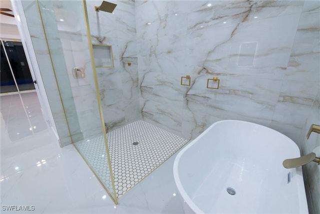 bathroom featuring shower with separate bathtub and tile walls