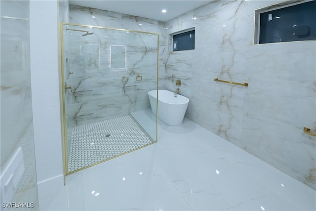 bathroom with tile walls and independent shower and bath