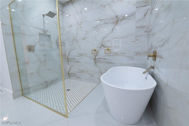 bathroom featuring tile walls and separate shower and tub