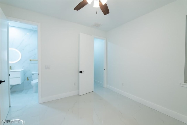 unfurnished bedroom featuring ceiling fan and ensuite bath