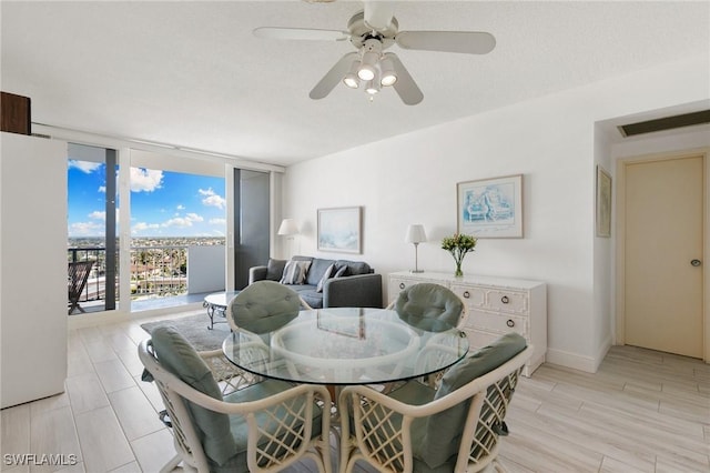 dining space with floor to ceiling windows, ceiling fan, a textured ceiling, and light hardwood / wood-style flooring