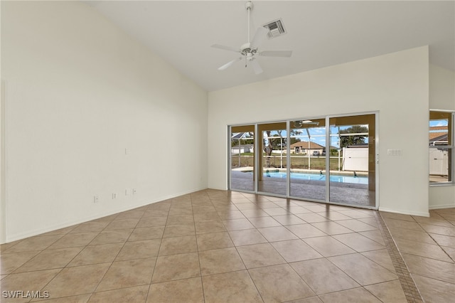 empty room featuring ceiling fan, high vaulted ceiling, and light tile patterned floors