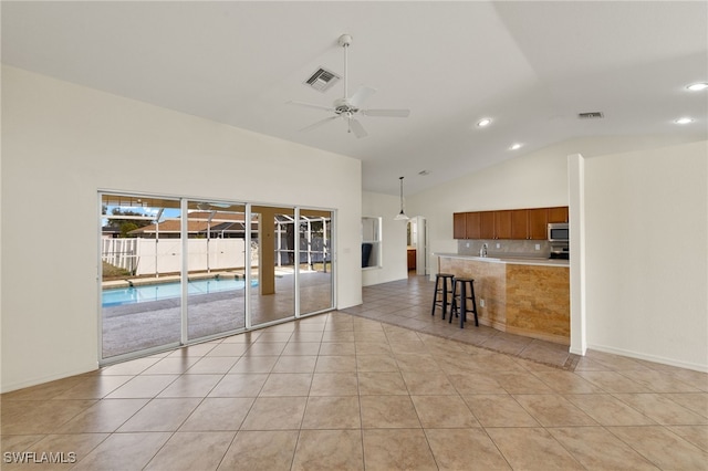 interior space with ceiling fan, high vaulted ceiling, and light tile patterned floors