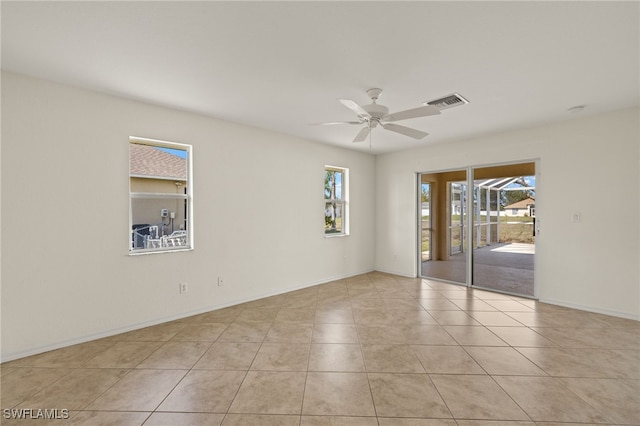 empty room with ceiling fan and light tile patterned floors