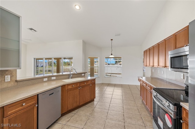 kitchen with sink, decorative backsplash, hanging light fixtures, light tile patterned floors, and stainless steel appliances