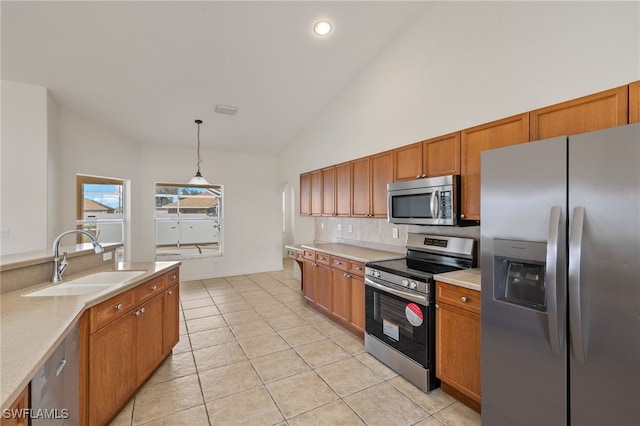 kitchen featuring light tile patterned flooring, sink, decorative light fixtures, high vaulted ceiling, and stainless steel appliances