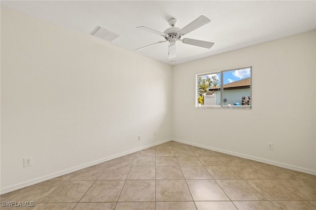 spare room with ceiling fan and light tile patterned floors