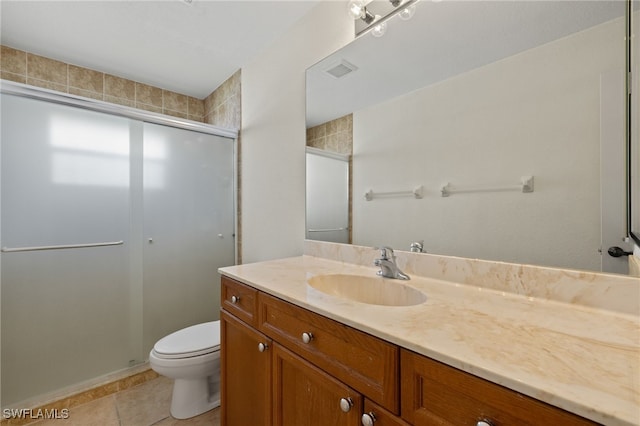 bathroom featuring vanity, toilet, a shower with shower door, and tile patterned flooring