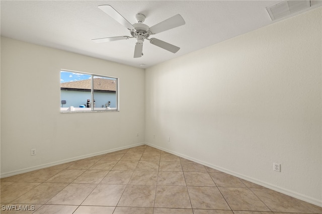 spare room with ceiling fan and light tile patterned floors