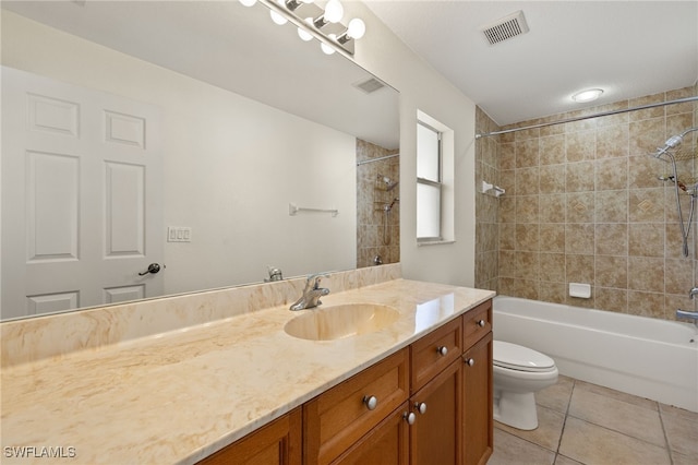 full bathroom with tile patterned flooring, vanity, tiled shower / bath, and toilet