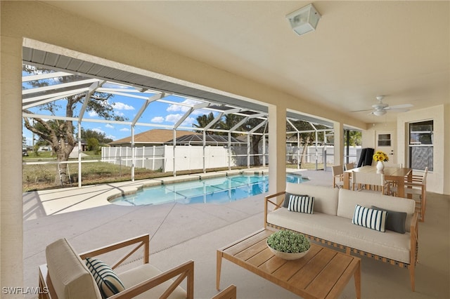 view of pool featuring ceiling fan, an outdoor living space, a patio area, and glass enclosure