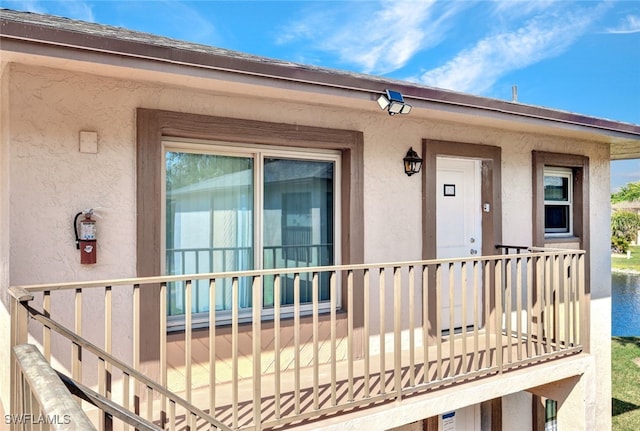 property entrance with a baseboard heating unit and stucco siding