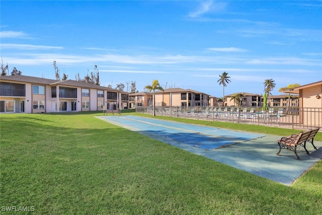 view of home's community with a yard, fence, and a residential view