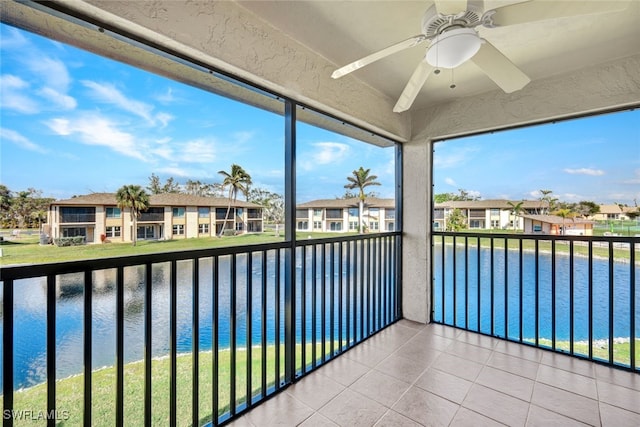 unfurnished sunroom with ceiling fan and a water view