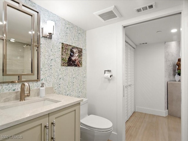 bathroom featuring vanity, hardwood / wood-style floors, and toilet